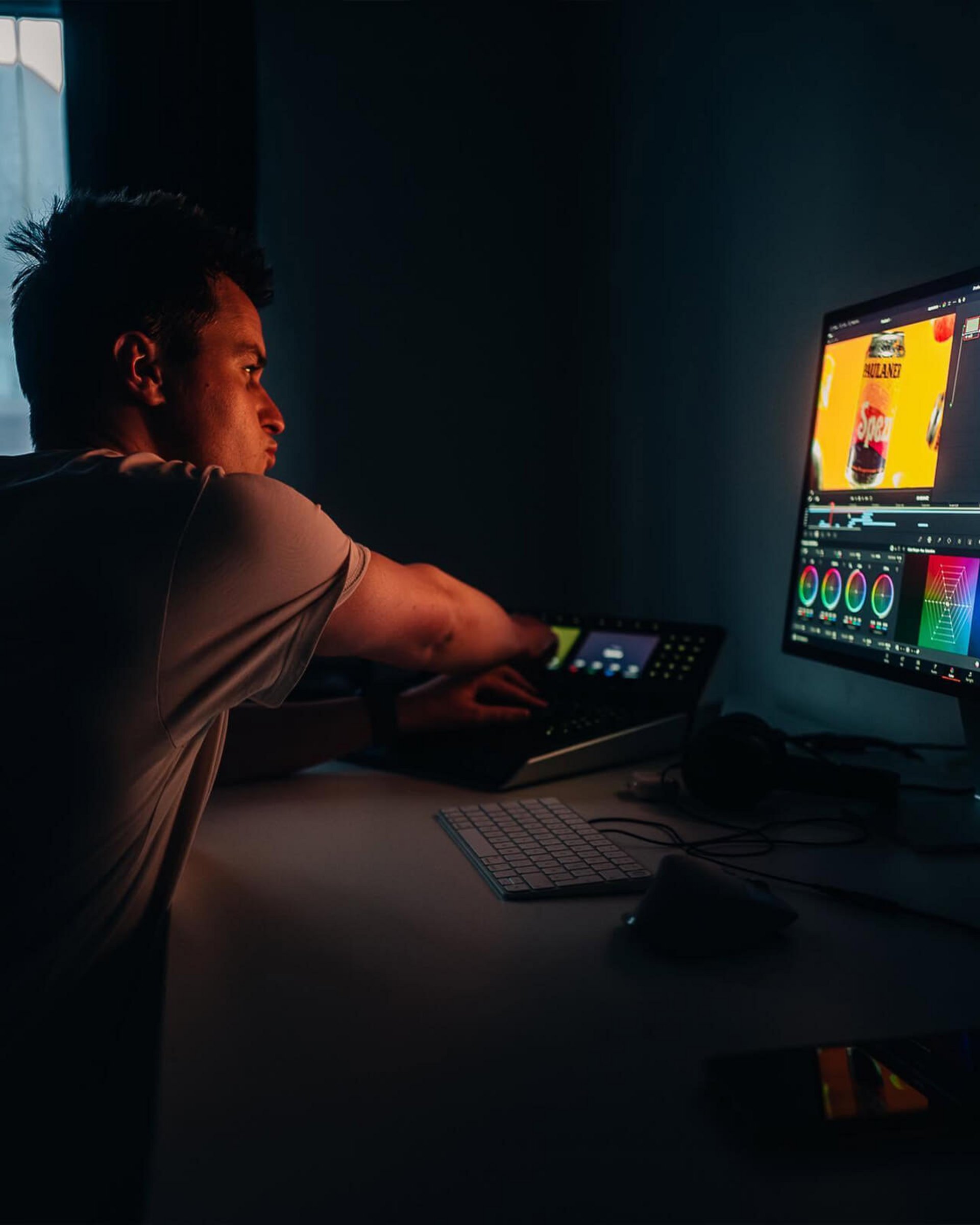 Colorist beim Color Grading am Panel im abgedunkelten Schnittraum